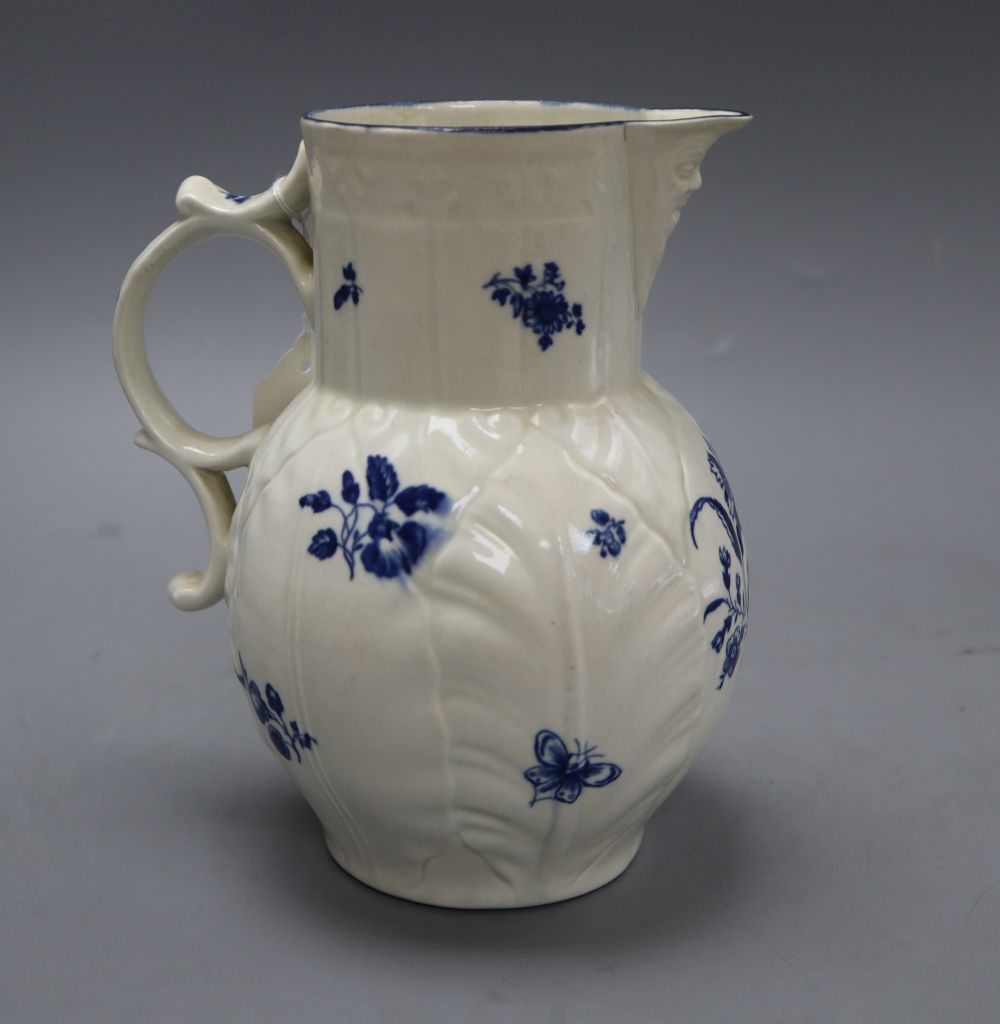 A Caughley cabbage leaf mask jug, c.1780, with scroll handle, decorated with floral sprays in underglaze blue, crescent mark, height